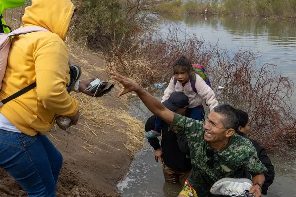 Asker, Ciudad Juarez 'deki bir nehirde göçmenlere yardım ediyor..