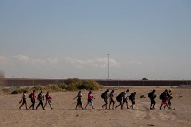 Siviller, Ciudad Juarez 'deki yüksek güvenlikli çitlere doğru göç etmenin acı gerçeklerini sembolize ederek ilerliyor..