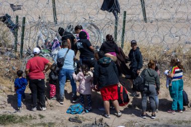 Eşyaları olan siviller, dikenli tellerle işaretlenmiş Ciudad Juarez sınırında toplandılar..