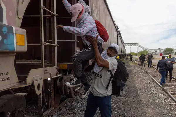 Adam çocuğa göç yolculuklarında kritik bir dönüm noktası olan Ciudad Juarez 'deki yük treninde yardım ediyor..