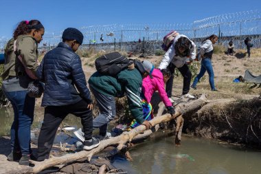 Siviller, Ciudad Juarez yakınlarındaki Rio Grande 'yi dolaşmak için geçici bir kütük köprüsü kullanıyorlar..