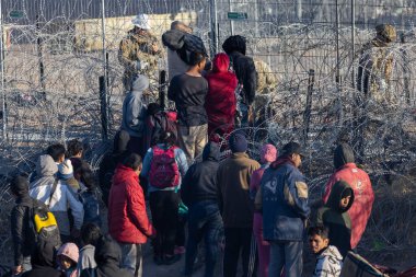 Ciudad Juarez sınırında toplanan siviller dikenli tellerin karşısındaki muhafızlarla iletişim halindeler..