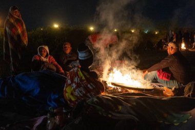 Battaniyeli göçmenler Ciudad Juarez 'de bir ateşin başında toplandılar..