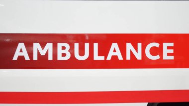 Arabanın arka kapısında büyük bir ambulans tabelası var.