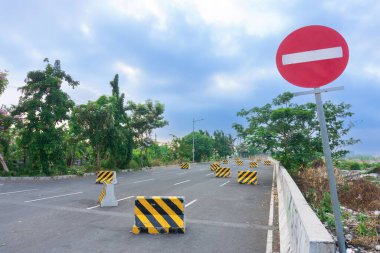 Trafik için sarı ve siyah geçici beton yol bölücülerinin arka planda girilmesi yasaklanmıştır.