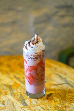 Çilek aromalı sütlü kahve, üstüne krema ve çikolata serpiştirilmiş..