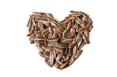 Delicious sunflower seeds in the shape of a love symbol isolated on a white background. clipart