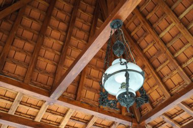 Çok sanatsal antik bir lambaya yakın, Java tarzı ahşap çatılı..