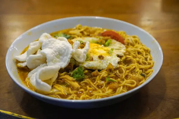 Yumurta, doğranmış tavuk ve krakerle kaplı Cava godok eriştesi..