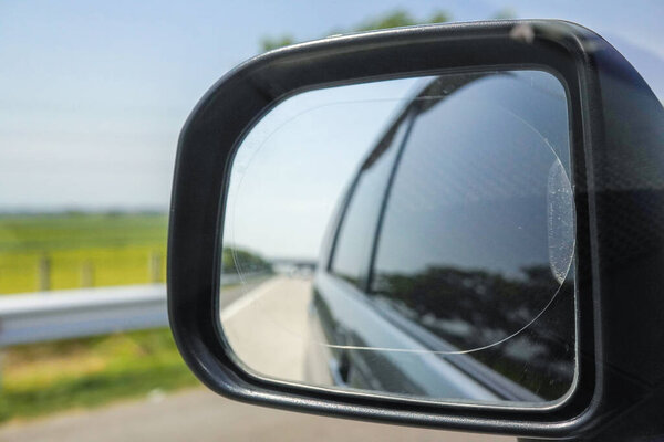 View of the toll road in the car's side mirror.