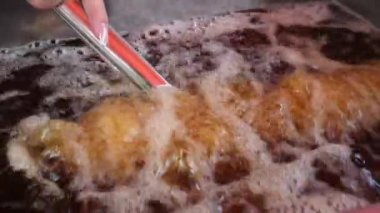 Kavrulmuş tuzlu Tornado Patates cipsi kızgın yağda pişen bir çubuğun üzerinde. Yüksek kalite 4k görüntü