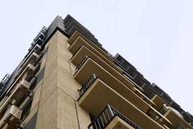 Balkonları ve klimaları olan modern konut binaları, temiz gökyüzüne karşı alçak açı.