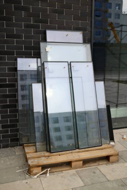 Modern binanın ön cephesindeki ahşap palette yalıtımlı cam camlar var.