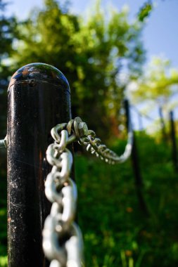 Black Metal Park Bollard 'a bağlı güvenlik zinciri, galvanizli çelik zincir halkalı sınır direğine yakın çekim