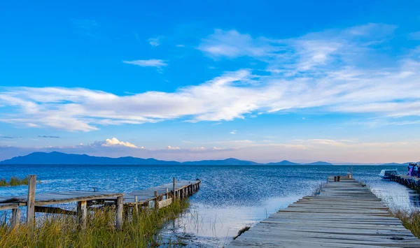 Mavi gökyüzü ve yeşil bitkilerle titicaca gölündeki iskelede