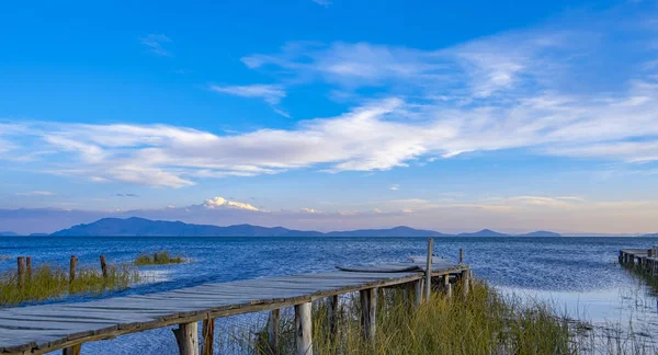 Mavi gökyüzü ve yeşil bitkilerle titicaca gölündeki iskelede