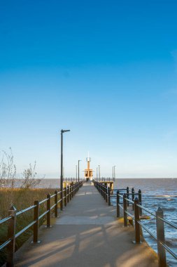 Gün batımında deniz feneriyle rıhtımın yatay fotoğrafı