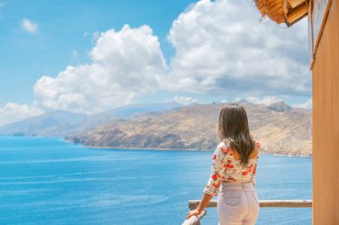 relaxed latin tourist woman looking at lake titicaca on the sun 