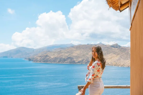 smiling young latin woman sightseeing in a boat on the shores of lake titicaca in bolivia