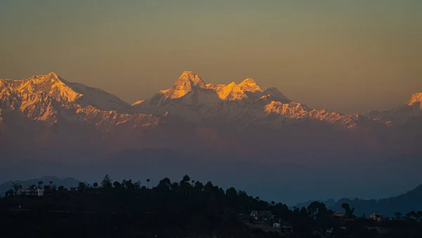 Himalayalar 'ın görünür siluetleriyle Binsar' daki renkli sislerin arasından görünen dağ siluetleri, Uttarakhand, Hindistan 'daki Almora bölgesindeki bir tepe istasyonu..