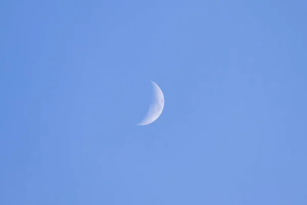 the moon in the sky during the daytime, approximated by a telescope