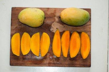 Mango meyveleri ve mango dilimleri. Kesme yolu.