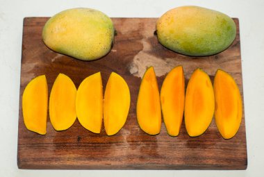 Mango meyveleri ve mango dilimleri. Kesme yolu.