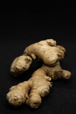 Siyah arkaplanda taze zencefil rhizomu izole edildi.