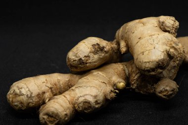 Siyah arkaplanda taze zencefil rhizomu izole edildi.