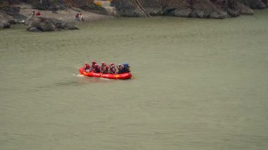 Uttarakhand, Rishikesh 'teki Ganges Nehri. Klip, Uttarakhand 'ın Rishikesh kentinde 10.05.2025 manzaralı bir arka planda beyaz su akıntılarında gezinen maceraperestlerin heyecanını yakalıyor. Hindistan 
