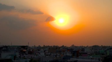 Dehradun, Uttarakhand 'da gün batımını gösteren 4K görüntüler. Kamera düzgün bir şekilde sağa döner, parlayan gökyüzünü, ılık ışığı ve yumuşak şehir siluetlerini ortaya çıkarır..