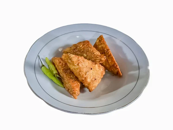 テンペ メンダン 小麦粉で包んだ三角形の揚げテンペは インドネシア人に人気の白いプレートにおいしい味を作り出します — ストック写真