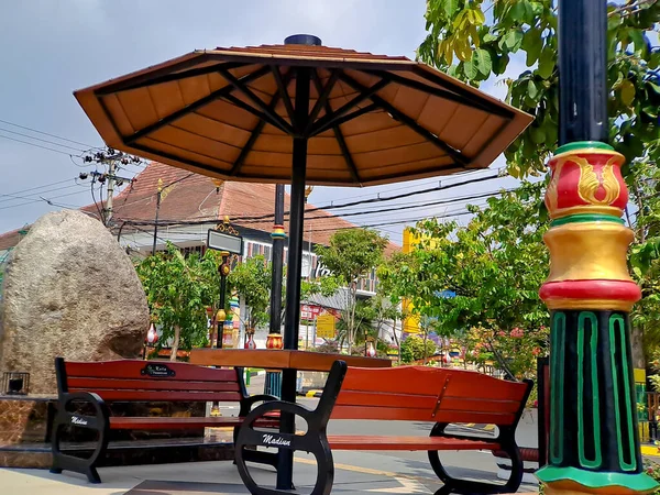 黒い茶色の木と鉄で作られた休憩所のベンチと傘 中央インドネシアの都市の庭で明るい青い空 — ストック写真