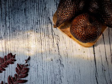 Salak, yaygın olarak yenen bir palmiye meyvesi türüdür. Sayan veya yılan meyvesi, bilimsel adı Salacca zalacca 'dır. beyaz tahta arkaplan