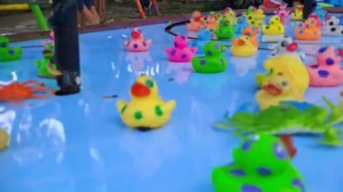 Duck fishing toy spinning on a blue wheel, in the park