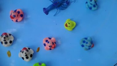 Duck fishing toy spinning on a blue wheel, in the park