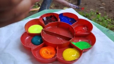 a child is coloring a picture of a styrofoam truck, in a park