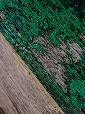 Fotoğrafta, üzerinde deniz mavisi boyası olan bir tahta parçası var. Doku pürüzlü ve yaşlanmış.