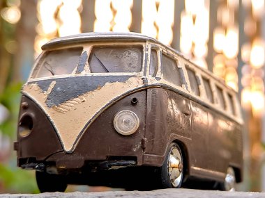 Eskimiş otobüs modeli, ikonik şekil, retro cazibe. Yeşillik arka plan, nostaljik cazibe.