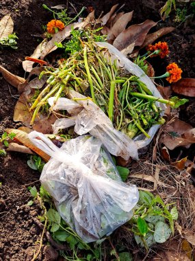 discarded food scraps and a plastic bag on a compost pile clipart