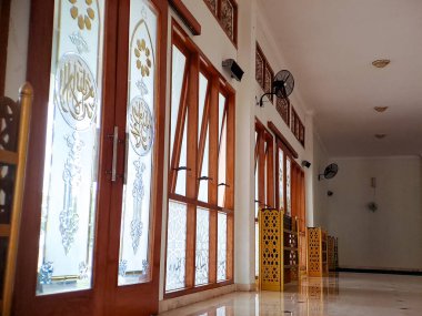 Karmaşık İslami el yazısı içeren vitray pencereli bir caminin iç görünümü