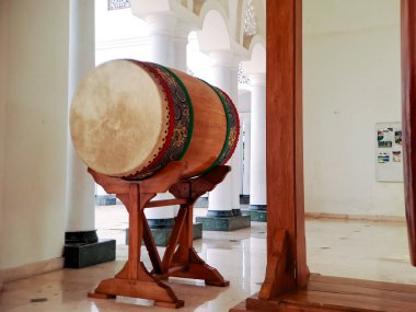 Geleneksel İslami davul kazılmış ve cami avlusunda asılı duran bir gong sehpası, inananları namaza çağırmaya hazır.