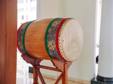 Geleneksel İslami davul kazılmış ve cami avlusunda asılı duran bir gong sehpası, inananları namaza çağırmaya hazır.
