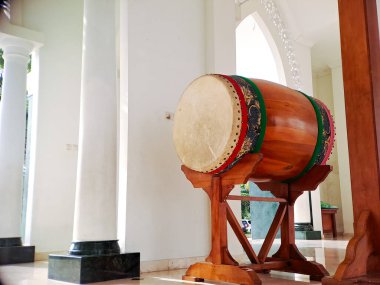 Geleneksel İslami davul kazılmış ve cami avlusunda asılı duran bir gong sehpası, inananları namaza çağırmaya hazır.