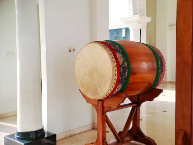 Geleneksel İslami davul kazılmış ve cami avlusunda asılı duran bir gong sehpası, inananları namaza çağırmaya hazır.