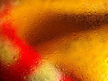 Bir yüzeyde su damlacıkları olan soyut arkaplan, sarı ve kırmızı renklerin canlı etkileşimini oluşturur