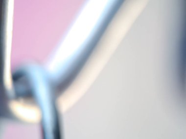 Yumuşak pembe renklere ve bulanık gümüş çizgilere sahip soyut bir arka plan modern bir estetik yaratıyor..