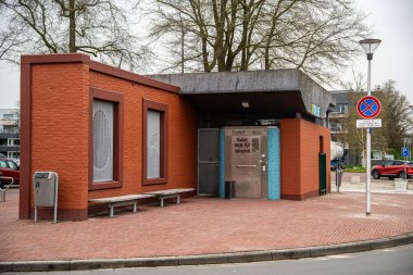 Ter Apel, Hollanda - 30 Mart 2024: Tuğla dış, metal kapı ve bankları olan umumi tuvalet binası