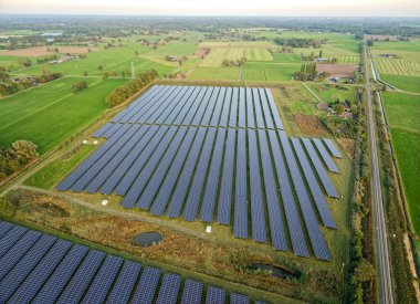 Yeşil kırsal alandaki büyük güneş paneli çiftliği, yenilenebilir enerji üretimi, hava aracı toplam
