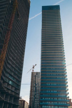 Residential buildings construction site with cranes. New build apartments house in skyscraper and housing building. Vertical orientation. Industrial concept